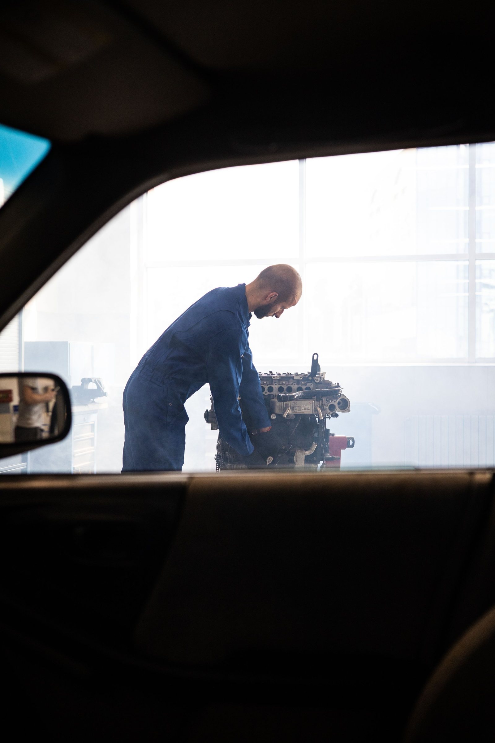 Auto body mechanic repairing a vehicle in a garage